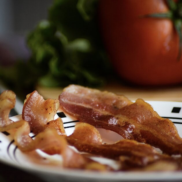 Crispy cooked bacon strips on a plate