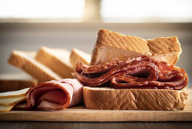 Fresh-sliced deli ham on bread with cheese