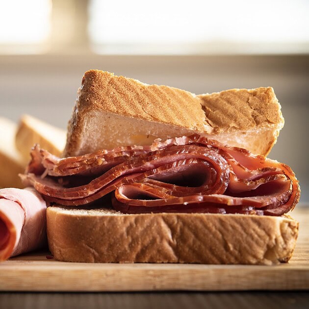 Fresh-sliced deli ham on bread with cheese