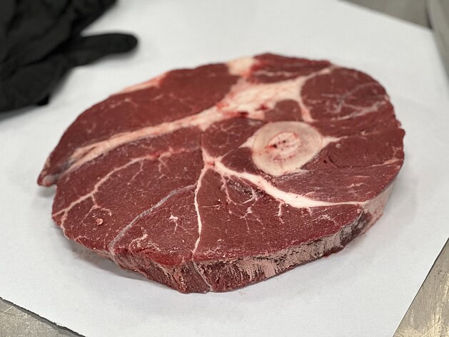 Raw cross-cut beef shank with marrow bone on butcher paper