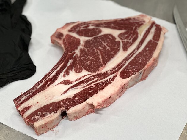 Raw bone-in rib roast on butcher paper