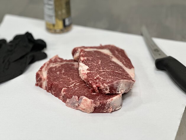 Raw boneless ribeye steaks on butcher paper