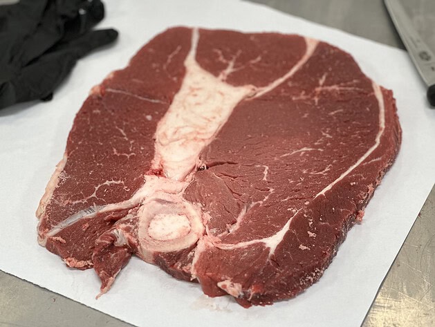 Raw bone-in round steak on butcher paper