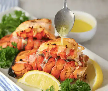 Two butterflied lobster tails with melted butter