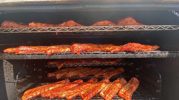 Ribs and meats smoking inside a commercial smoker at Homestead Meat Company