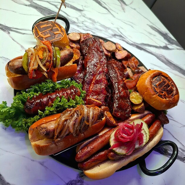 Premium grilled meats and sausages with fresh vegetables and sides.