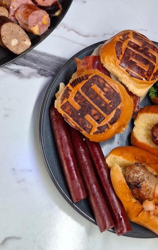 Assorted gourmet meats and sausages on a plate, perfect for grilling or snacking.